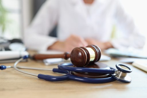 Closeup,Of,Judge,Gavel,Of,Stethoscope,Doctor,In,Background,Writing