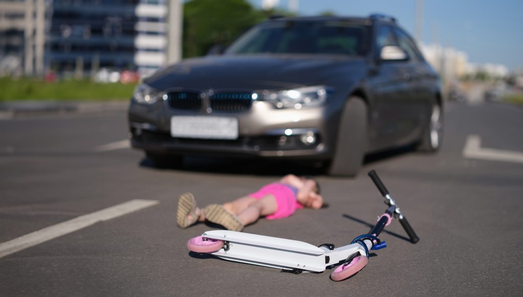 Little,Girl,Lies,On,Asphalt,With,Scooter,After,Collision,With