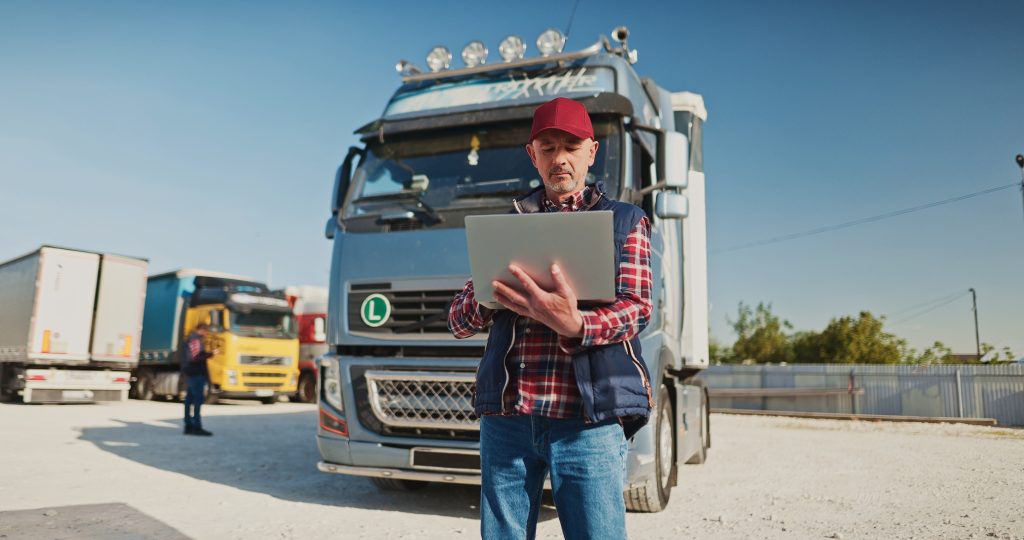 Truck,Driver,Holding,A,Laptop,And,Checking,The,Fuel,Level